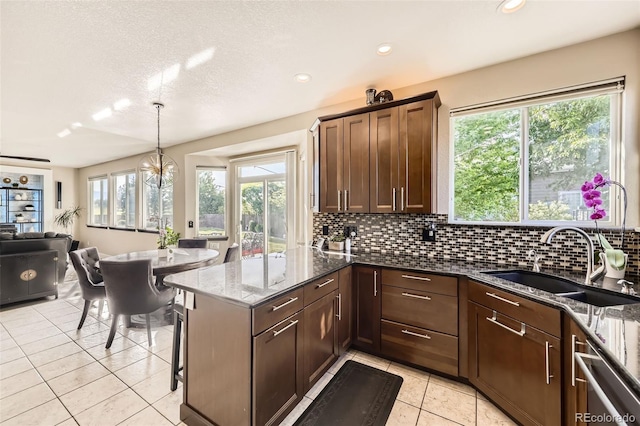 12693 W 82nd Ln, Arvada, CO 80005 - kitchen featuring a sink, light tile patterned flooring, dark stone counters, backsplash, and dishwasher