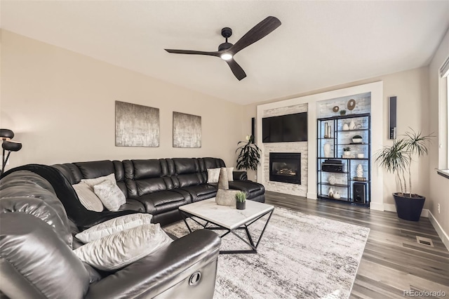 12693 W 82nd Ln, Arvada, CO 80005 - living room featuring a ceiling fan, wood finished floors, a glass covered fireplace, and baseboards
