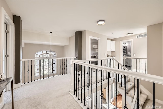 12693 W 82nd Ln, Arvada, CO 80005 - hallway with a chandelier, carpet floors, and an upstairs landing