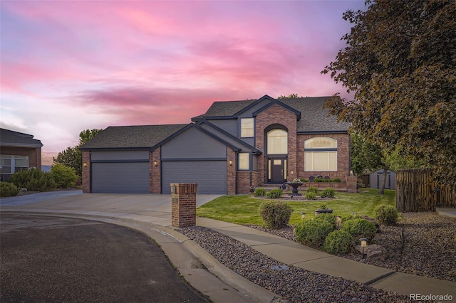 12693 W 82nd Ln, Arvada, CO 80005 - view of front of house with driveway, brick siding, a yard, an attached garage, and roof with shingles