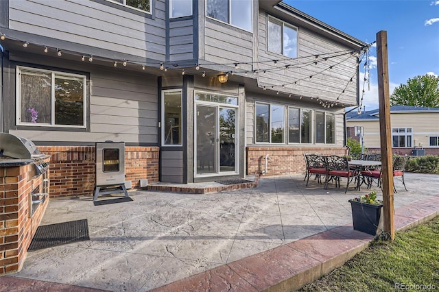 12693 W 82nd Ln, Arvada, CO 80005 - rear view of house with a patio, brick siding, and an outdoor kitchen