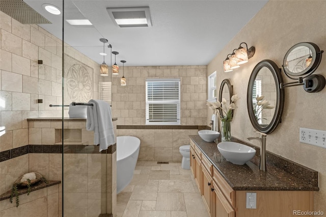 3182 Cimarron Pl, Superior, CO 80027 - bathroom with visible vents, a freestanding tub, a sink, tile walls, and a tile shower