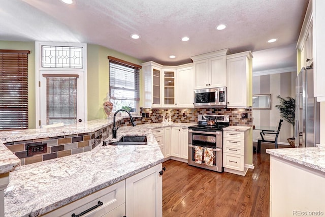 kitchen featuring white cabinetry, stainless steel appliances, light stone countertops, and sink