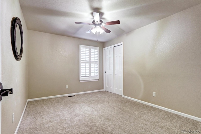 spare room featuring carpet, a textured ceiling, and ceiling fan