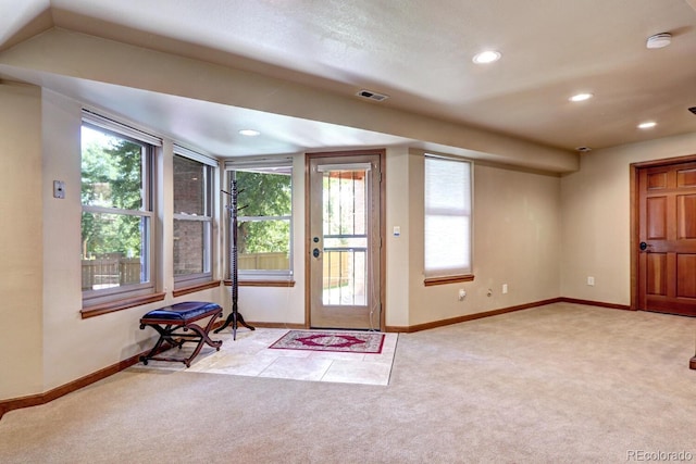 doorway with a healthy amount of sunlight and light carpet