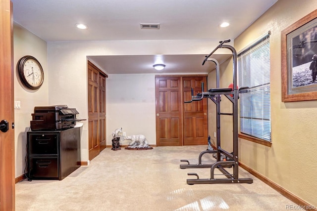 workout room featuring light colored carpet