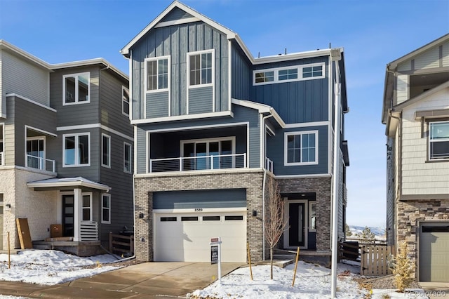 view of front of home with board and batten siding, concrete driveway, brick siding, and an attached garage