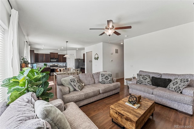 living room with a ceiling fan, recessed lighting, and dark wood-type flooring