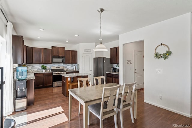 dining space with dark wood-style flooring, baseboards, and recessed lighting