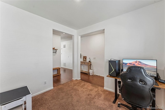 home office with carpet floors, baseboards, and visible vents