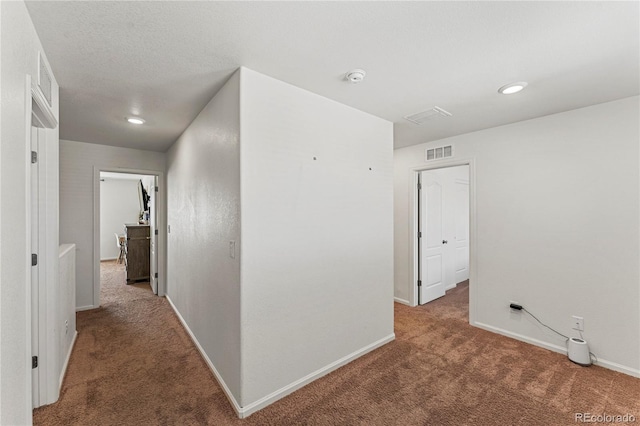 corridor with carpet flooring, recessed lighting, baseboards, and visible vents