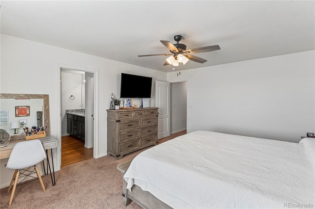 bedroom featuring connected bathroom, a ceiling fan, and light colored carpet