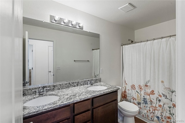 full bathroom with visible vents, a sink, double vanity, and toilet
