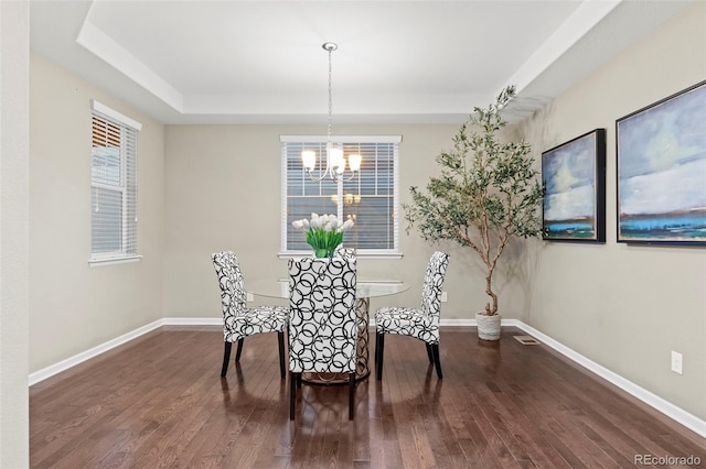 dining space with dark hardwood / wood-style flooring and a chandelier