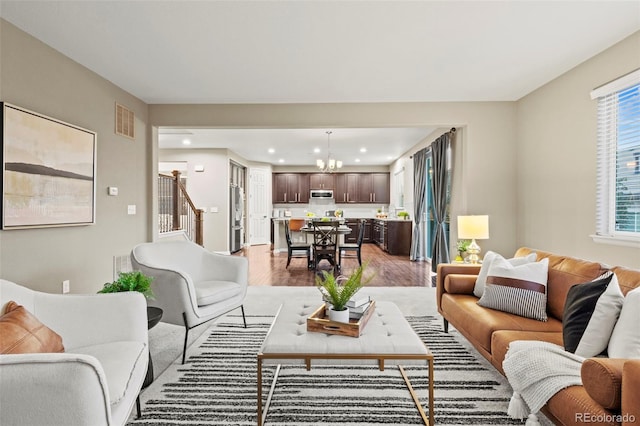 living room with a chandelier and light hardwood / wood-style flooring