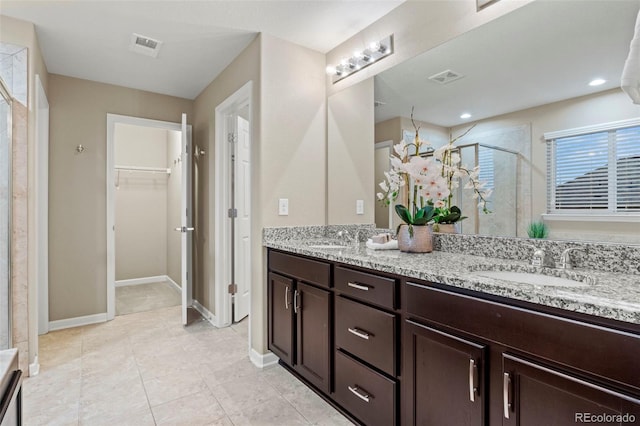 bathroom featuring walk in shower, vanity, and tile patterned flooring