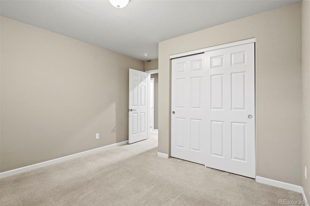 unfurnished bedroom with light carpet and a closet