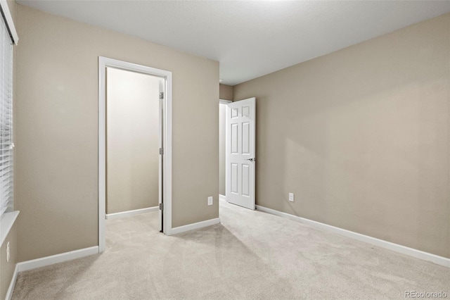 unfurnished bedroom with light carpet and a closet