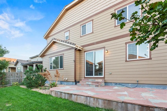 back of house featuring a patio and a lawn