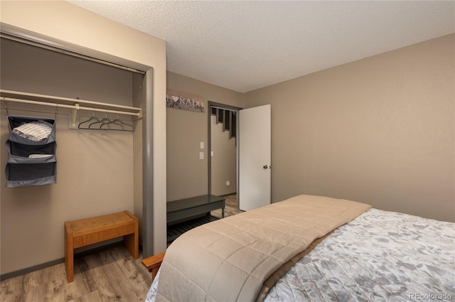 bedroom featuring a textured ceiling, a closet, and wood-type flooring