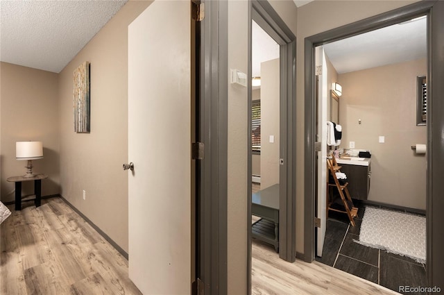 corridor featuring a textured ceiling and hardwood / wood-style flooring