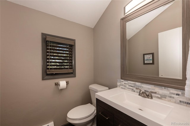 bathroom featuring lofted ceiling, toilet, decorative backsplash, and vanity