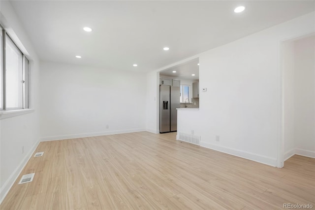 7956 Joan Dr, Denver, CO 80221 - spare room with light wood finished floors, recessed lighting, a sink, and baseboards