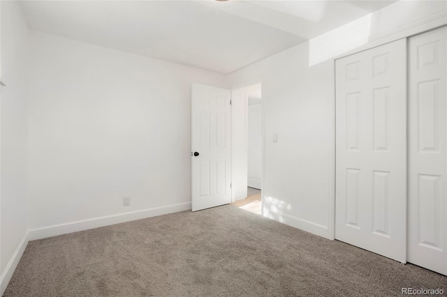 unfurnished bedroom with light carpet and a closet