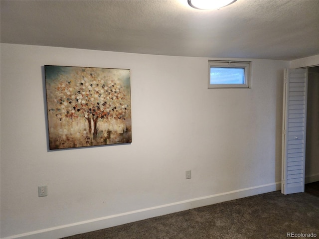 interior space with a textured ceiling and dark carpet