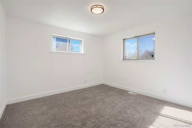 empty room featuring carpet flooring and plenty of natural light