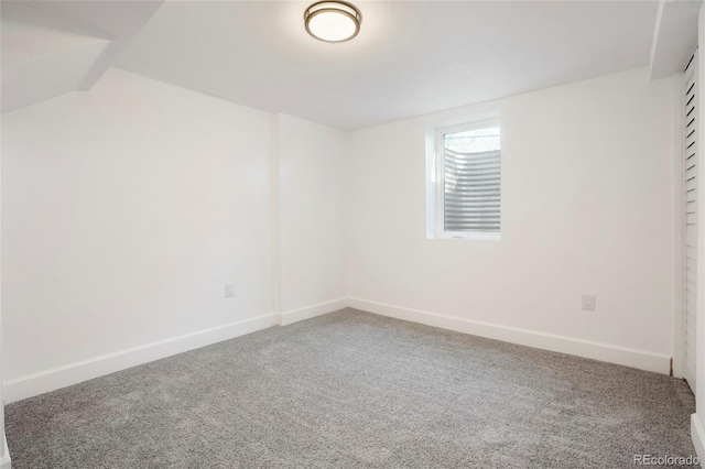 empty room with carpet and vaulted ceiling