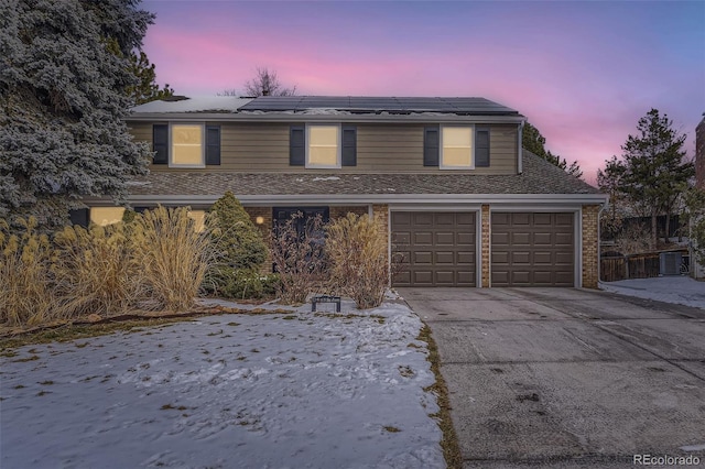 view of property featuring a garage and solar panels