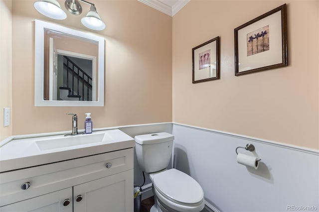 bathroom with toilet, crown molding, and vanity