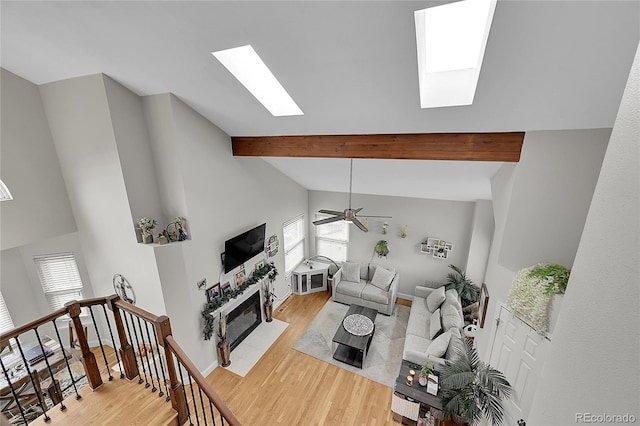 living room with a wealth of natural light, light hardwood / wood-style flooring, and lofted ceiling with skylight