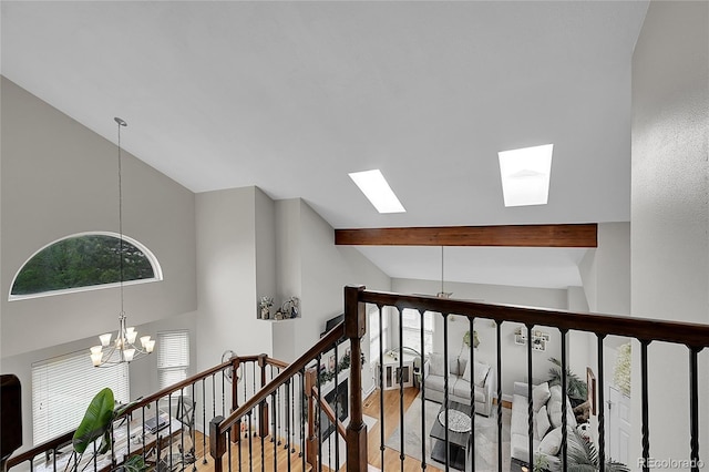 hallway with beamed ceiling, high vaulted ceiling, hardwood / wood-style flooring, and a chandelier