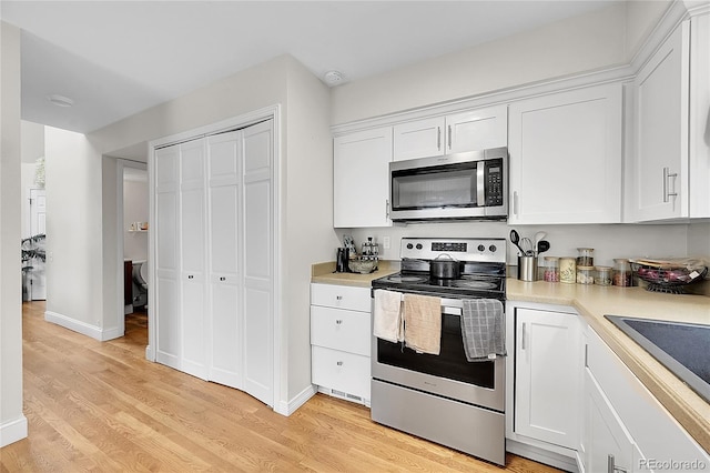 kitchen with white cabinetry, appliances with stainless steel finishes, sink, and light wood-type flooring