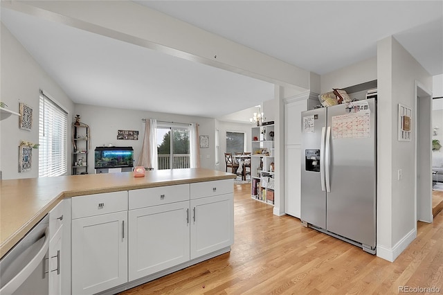 kitchen featuring decorative light fixtures, stainless steel appliances, kitchen peninsula, and white cabinets