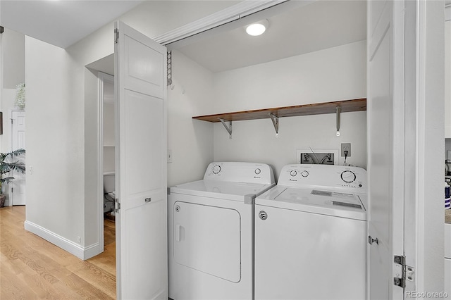 laundry room featuring washing machine and dryer and light hardwood / wood-style floors