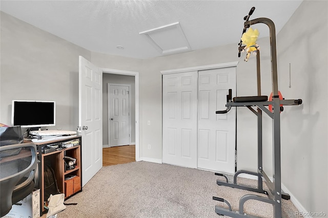 workout area with light colored carpet and a textured ceiling