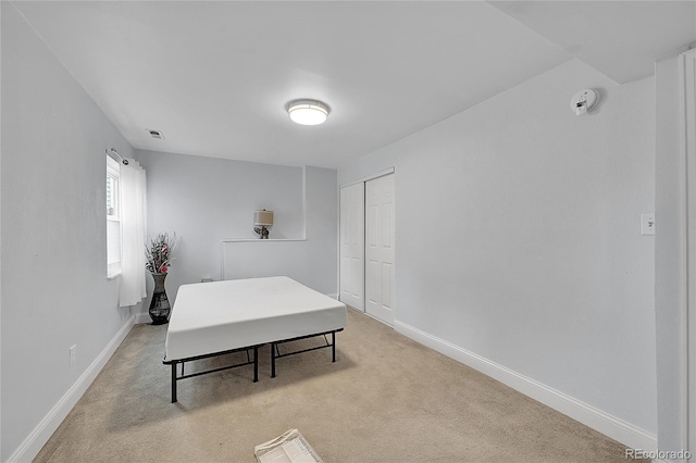 bedroom with light carpet and a closet