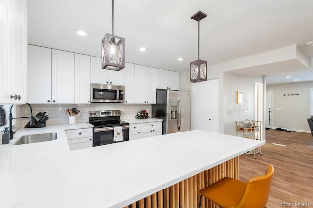 kitchen with decorative backsplash, sink, hanging light fixtures, and stainless steel appliances