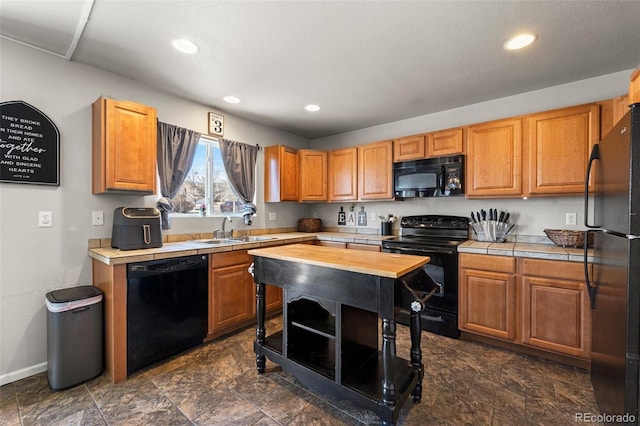 kitchen featuring wood counters, sink, and black appliances