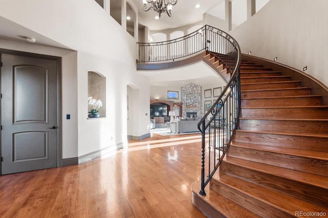 5810 Amber Ridge Dr, Castle Pines, CO 80108 - entrance foyer with a high ceiling, wood finished floors, a chandelier, stairs, and arched walkways