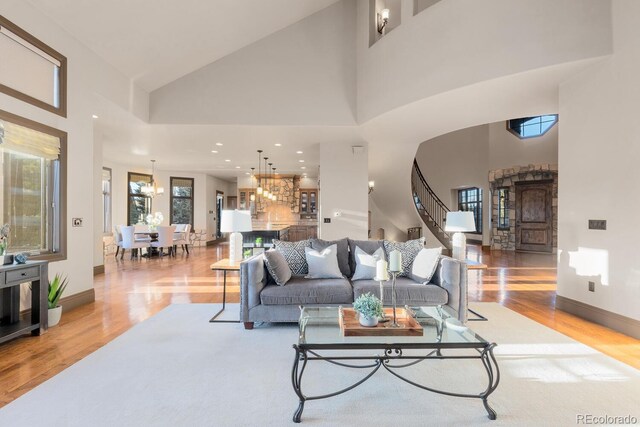 5810 Amber Ridge Dr, Castle Pines, CO 80108 - living room with wood finished floors, a towering ceiling, stairway, baseboards, and recessed lighting