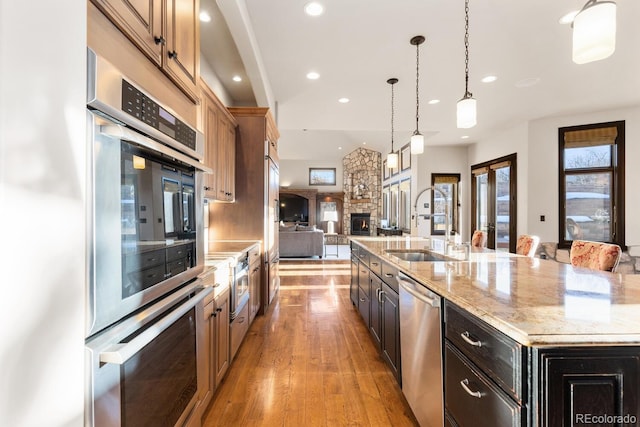 5810 Amber Ridge Dr, Castle Pines, CO 80108 - kitchen featuring appliances with stainless steel finishes, open floor plan, a sink, a large island, and recessed lighting