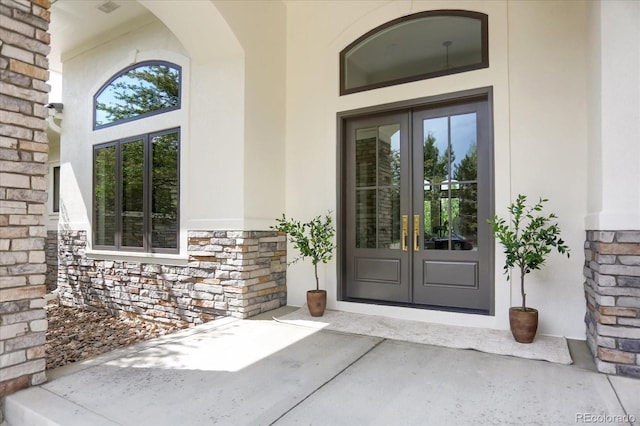 8937 Little Raven Trl, Niwot, CO 80503 - property entrance featuring french doors, stucco siding, and stone siding