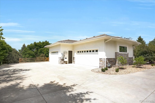 8937 Little Raven Trl, Niwot, CO 80503 - view of side of property with stone siding, driveway, stucco siding, and an attached garage