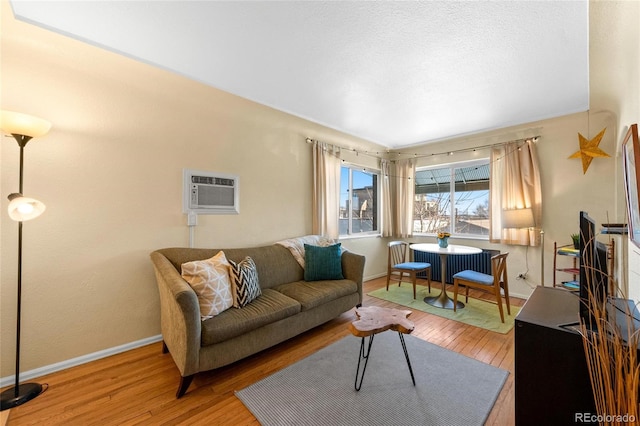 living room featuring a wall mounted AC and light hardwood / wood-style flooring