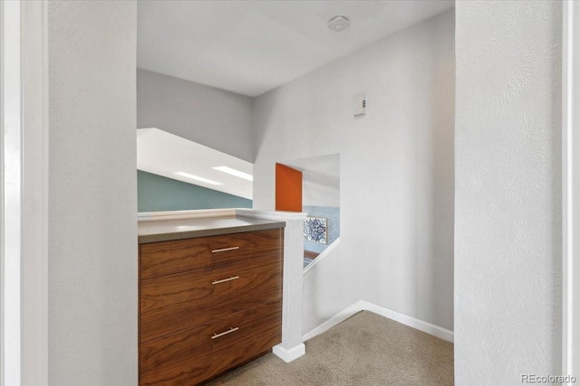 interior space featuring light carpet and baseboards