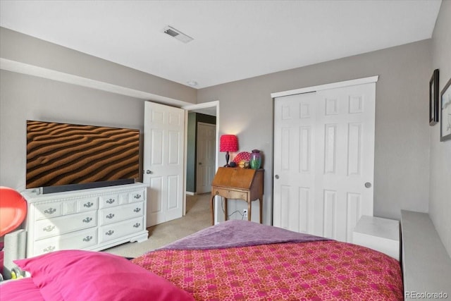 bedroom with visible vents, a closet, and light colored carpet